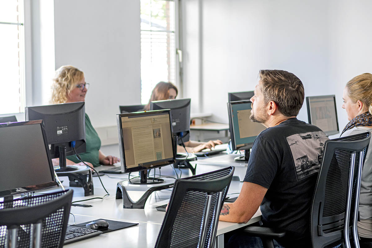 Foto von Menschen vor Computern bei einer Schulung